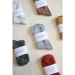 Collection of soft, flexible everyday socks in earthy colors with paper labels