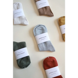 Collection of soft, flexible everyday socks in earthy colors with paper labels