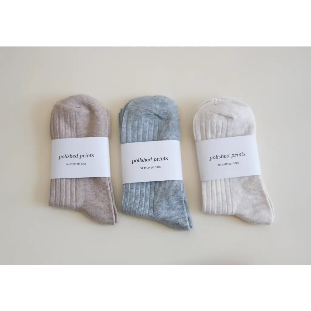 Three pairs of soft, flexible everyday socks in beige, blue-gray, and white