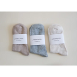 Three pairs of soft, flexible everyday socks in beige, blue-gray, and white