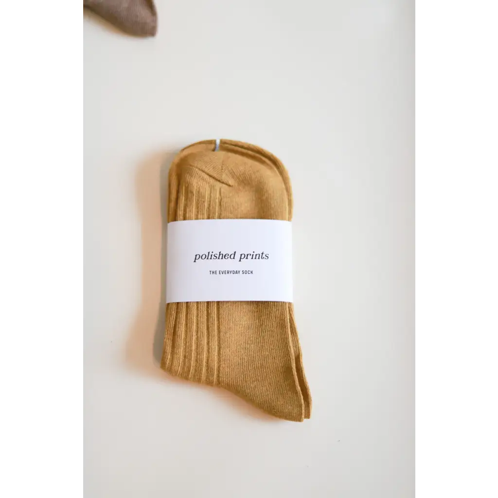 Folded mustard-yellow sock with a label, perfect for soft and flexible everyday wear