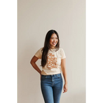 Person rocking a Cream Love Graphic T-shirt with polished prints and blue jeans