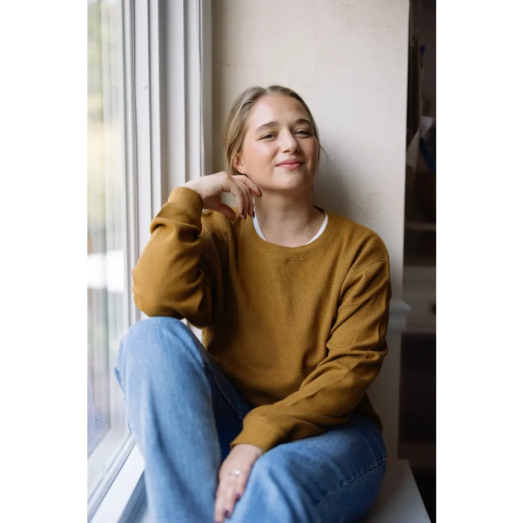 Person in a mustard yellow Jenna Knitted Waffle Longsleeve Pullover and light blue jeans