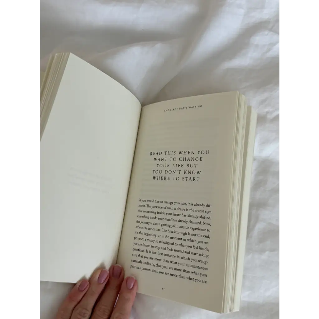 Open white book with pink nail polish from The Life That’s Waiting, perfect for stylish womens clothes