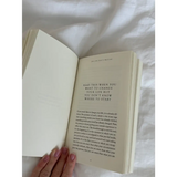 Open white book with pink nail polish from The Life That’s Waiting, perfect for stylish womens clothes
