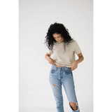 Curly-haired person rocking a Chill in the Mom Crop Tee in Bone White for a polished look