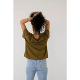 Person in an olive green mom crop boxy tee and light blue jeans, showing off casual style