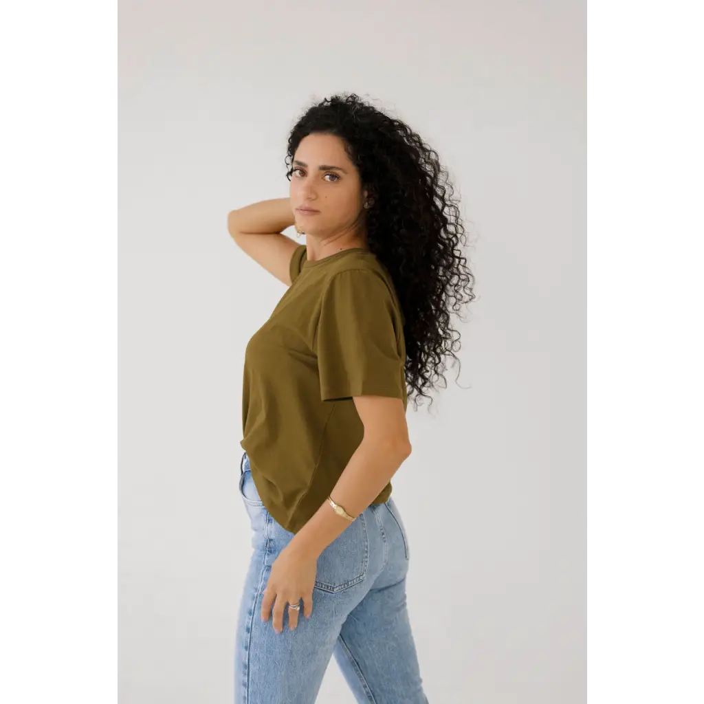 Person in an olive green mom crop boxy tee and light blue jeans for a casual look