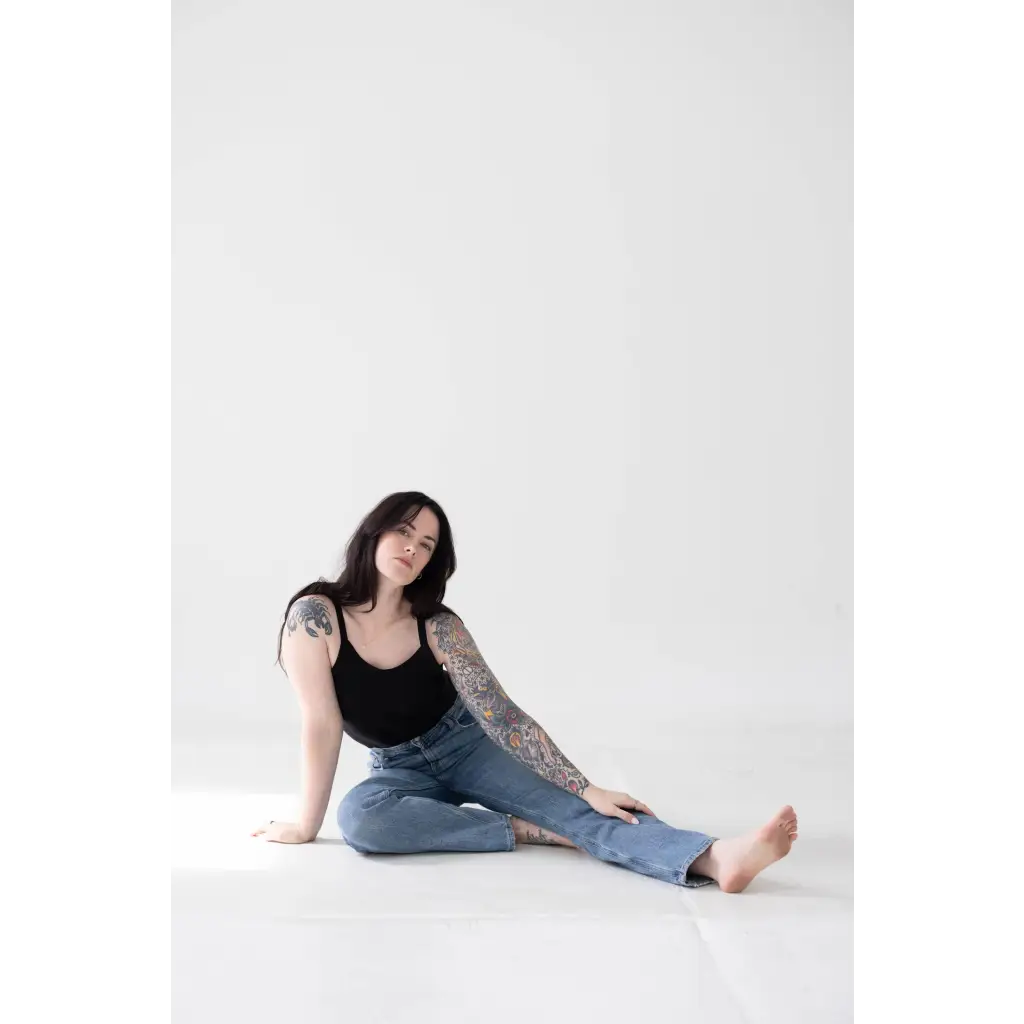 Person in Jet Black Mom Tank with Polished Prints, chilling in blue jeans on the floor