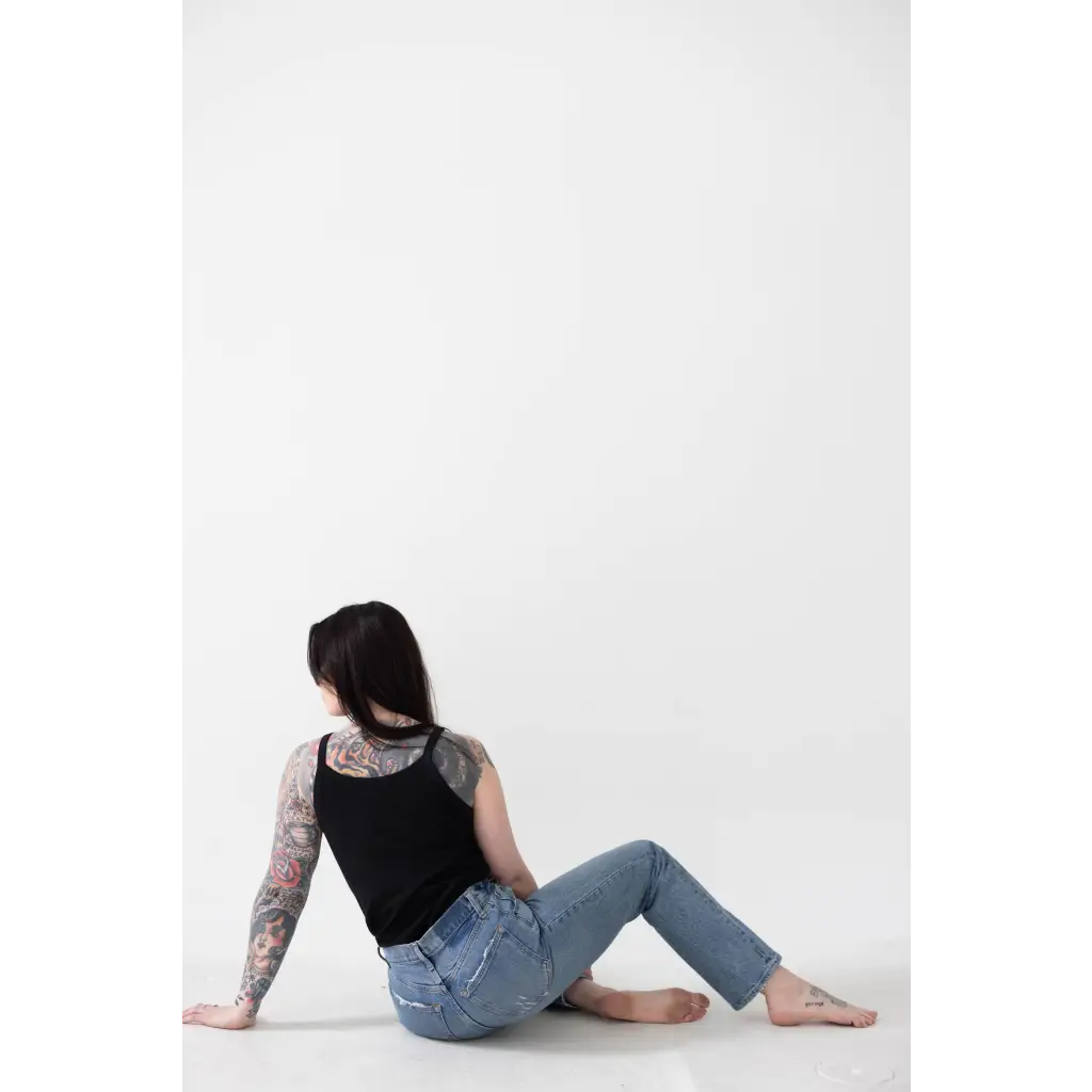 Person in a Jet Black Mom Tank with Polished Prints chilling on the floor in jeans