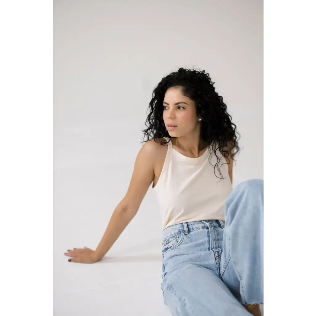 Person in a white transitional tank and light blue jeans showcasing the Mom Tank style
