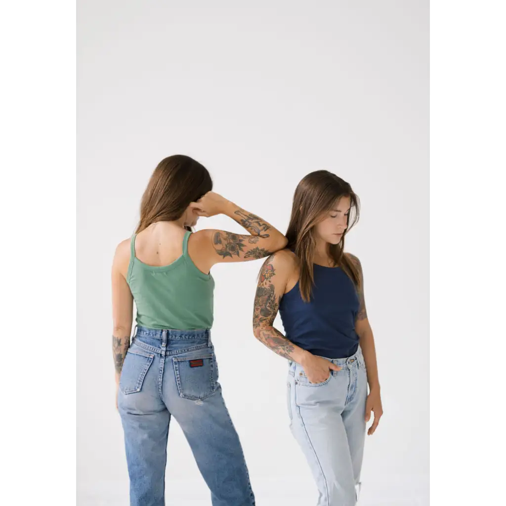 Two people in tank tops and jeans showing off the Navy Transitional Mom Tank with recommended sizing