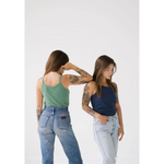 Two people in tank tops and jeans showing off the Navy Transitional Mom Tank with recommended sizing