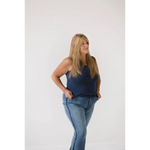 Person in navy transitional mom tank top and blue jeans showing recommend sizing