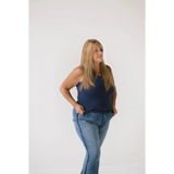 Person in navy transitional mom tank top and blue jeans showing recommend sizing