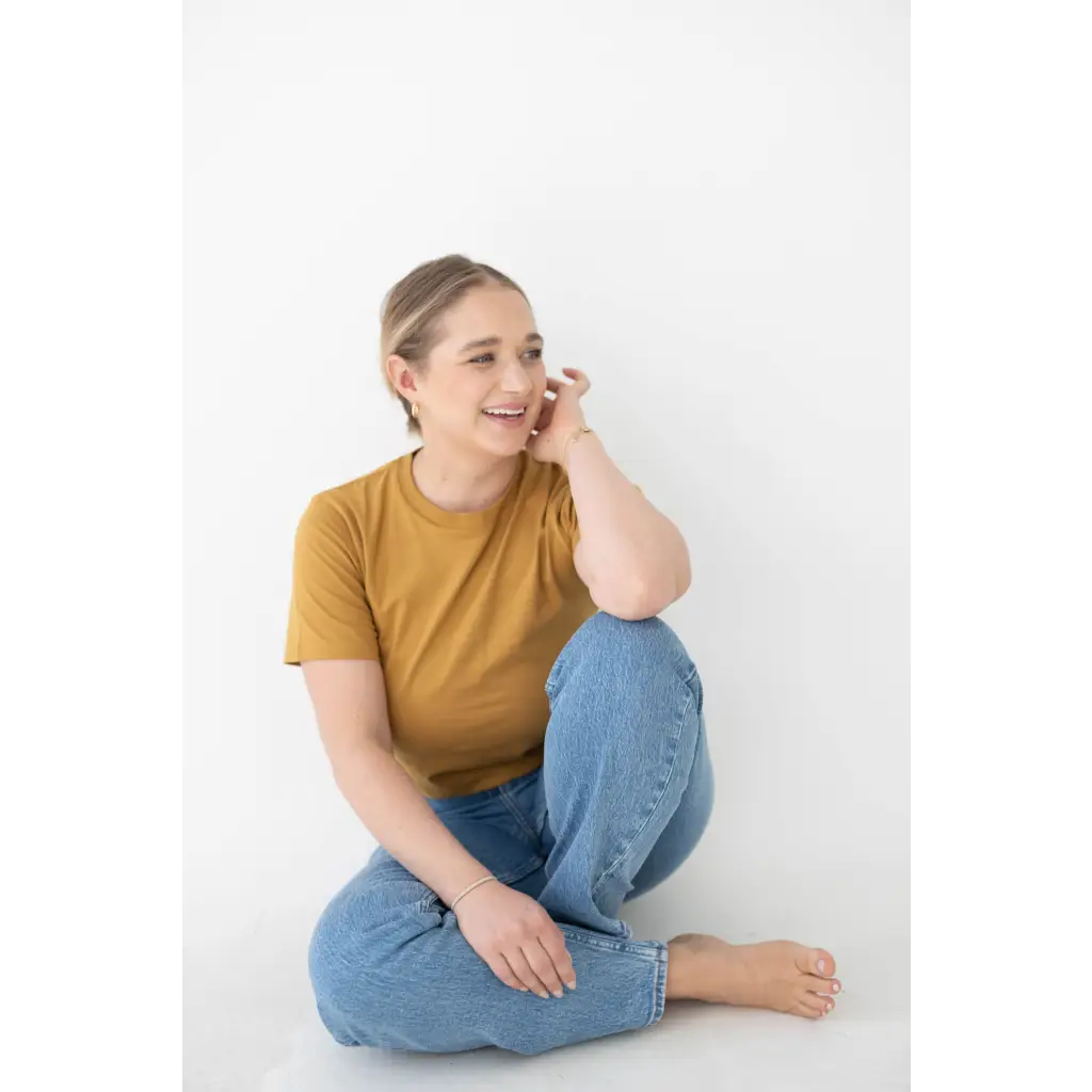 Happy person in a mustard yellow mom tee made from organic cotton and spandex blend