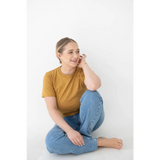 Happy person in a mustard yellow mom tee made from organic cotton and spandex blend