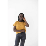 Person in a yellow mom tee made of organic cotton and spandex blend chatting on the phone
