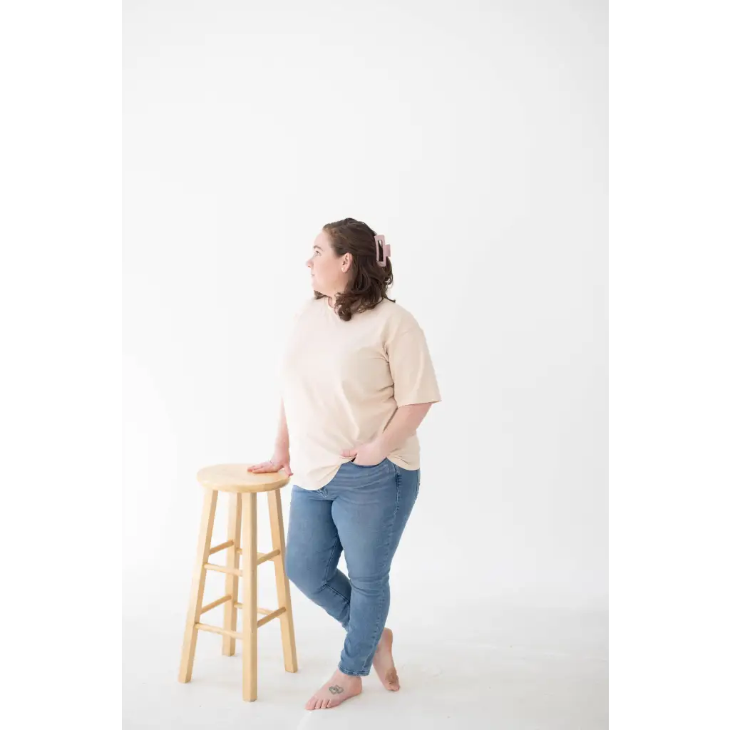 Wooden bar stool with round seat, perfect for pairing with a Cream Mom Tee in Organic Cotton