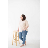 Wooden bar stool with round seat, perfect for pairing with a Cream Mom Tee in Organic Cotton