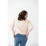 Person in cream Mom Tee made from organic cotton and spandex blend, seen from behind