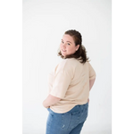 Person in a beige sweater and blue jeans showcasing the Cream Mom Tee in Organic Cotton Spandex Blend