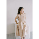Cute peach-colored floral play dress with smocked bodice and shoulder ties for kids