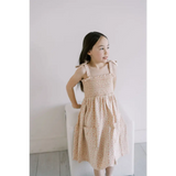 Cute peach-colored floral play dress with smocked bodice and shoulder ties for kids