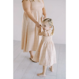 Two kids in matching cream smock dresses, perfect for playtime and mini floral fun