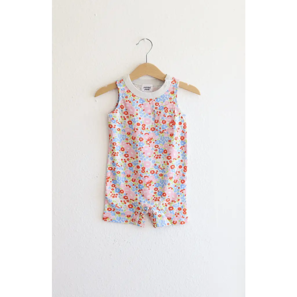 Floral sleeveless romper on a wooden hanger for toddlers in super soft organic cotton