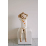Child in cream pajamas with orange palm trees, perfect for dreams of distant galaxies