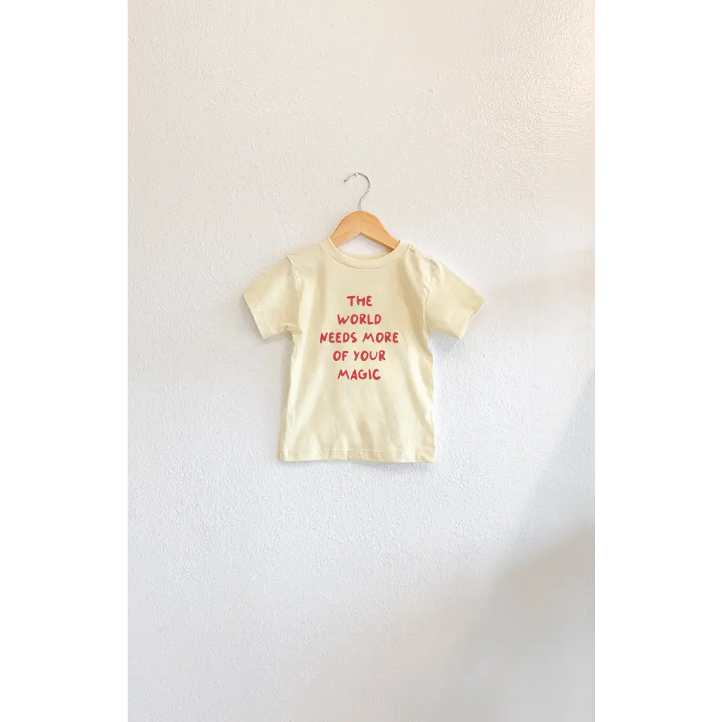 Yellow t-shirt with bold red lettering for kids from The World Needs More of Your Magic