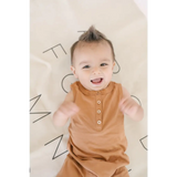 Joyful baby in a caramel Henley Shorty Romper, perfect for little explorers