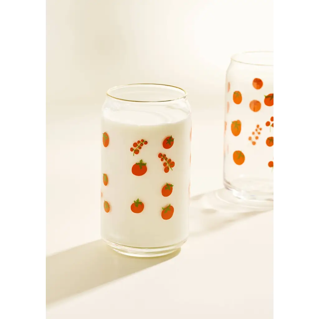 Clear glass cup with red berry pattern and white milk, perfect for stylish womens clothes