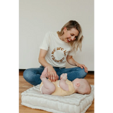 Baby enjoying a gentle massage on a white cushion by a change graphic t-shirt design