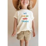 Child wearing We Can Do Hard Things Kids Graphic T-Shirt with fade-resistant inks