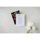 Two books with floral art and poetry excerpts beside white flowers, with free shipping