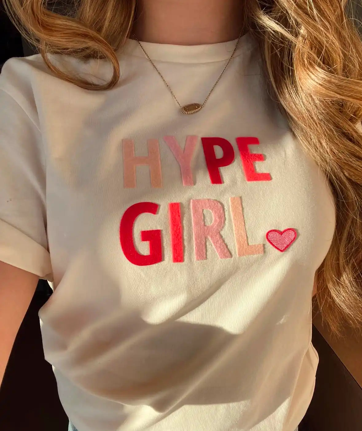 White t-shirt with ’HYPE GIRL’ text in pink and red letters and a small heart design.