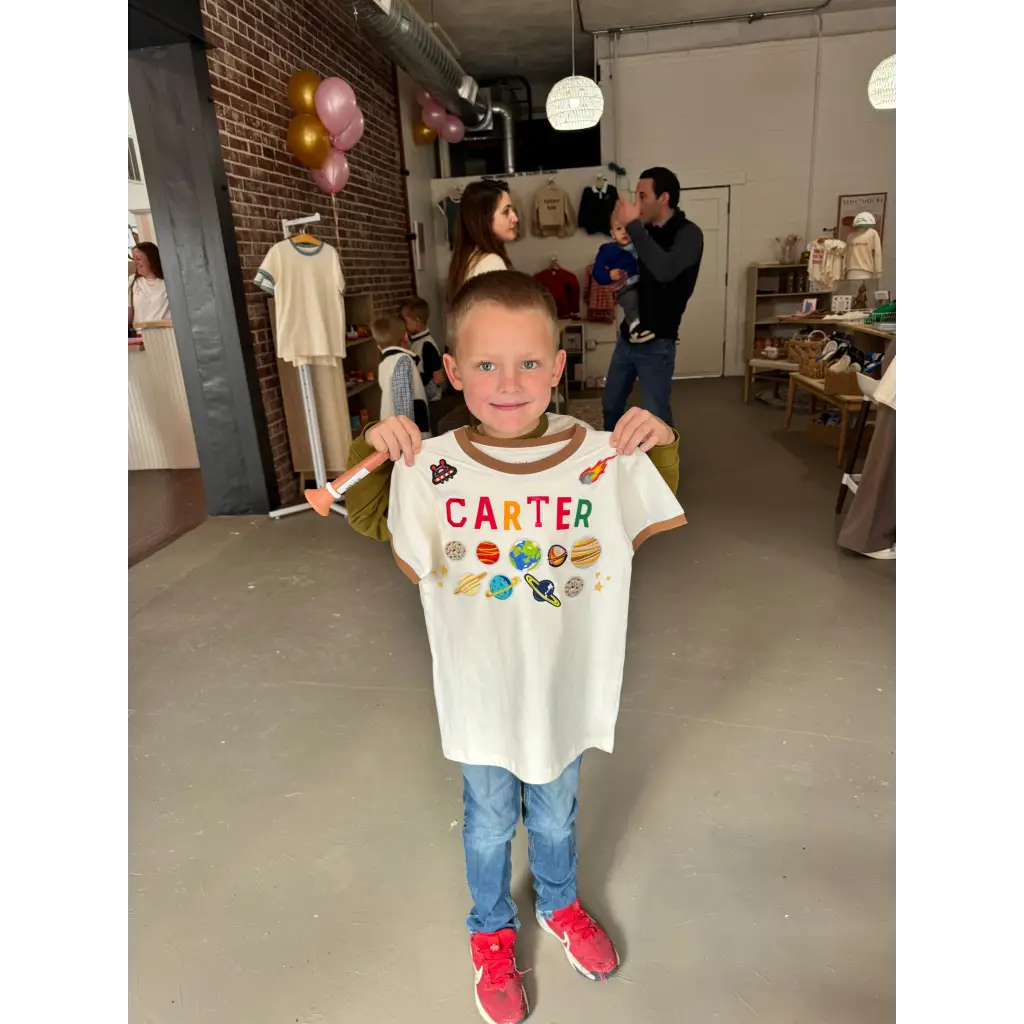 White Carter t-shirt with colorful planets and brown trim by Polished Prints