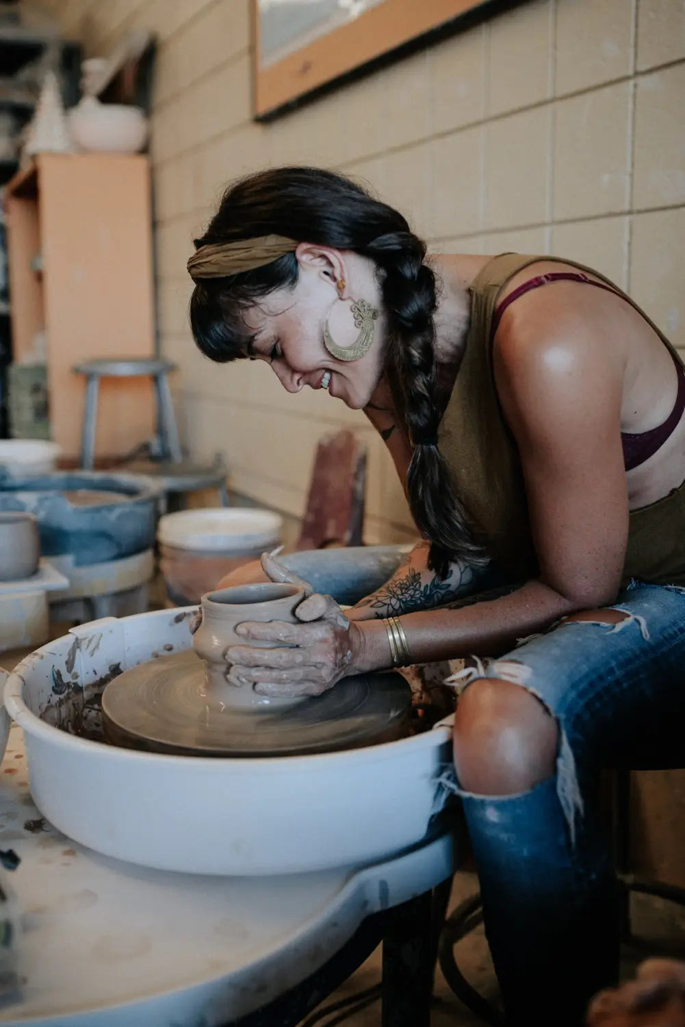 Janna Barker shaping clay on a pottery wheel in her San Diego small business studio