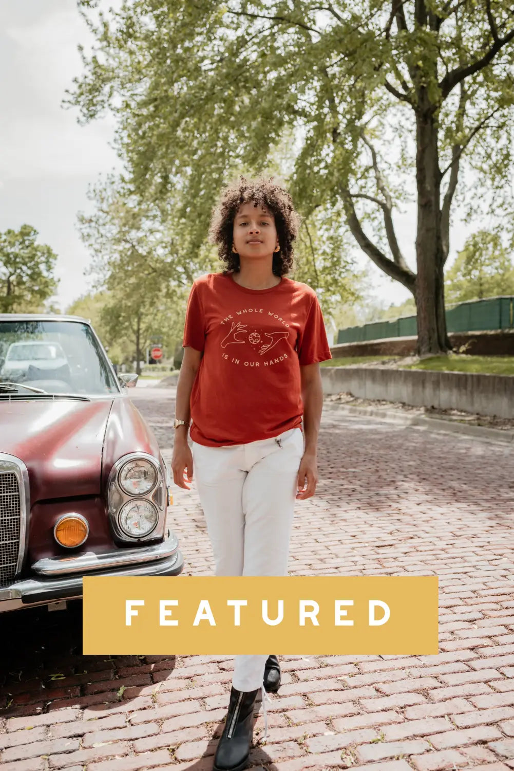 Person in red t-shirt and white pants by vintage Mercedes-Benz for kid’s pullover sale.