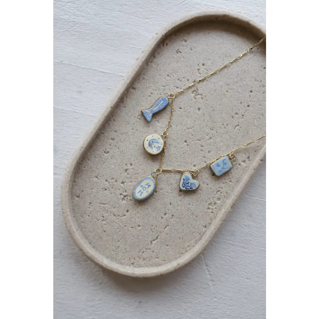 Delicate gold chain necklace with 5 light blue ceramic peace signs camp charms