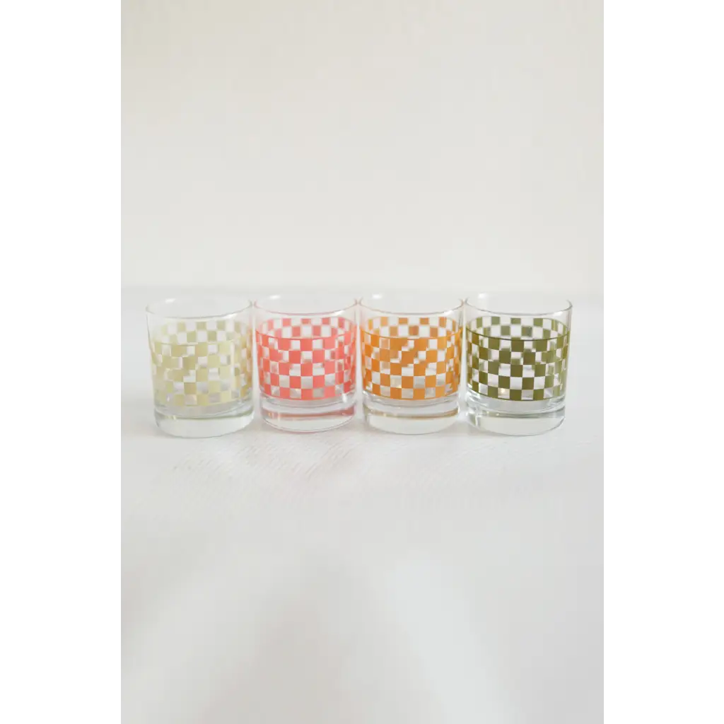 Four pastel checkered glasses lined up for a stylish cocktail experience