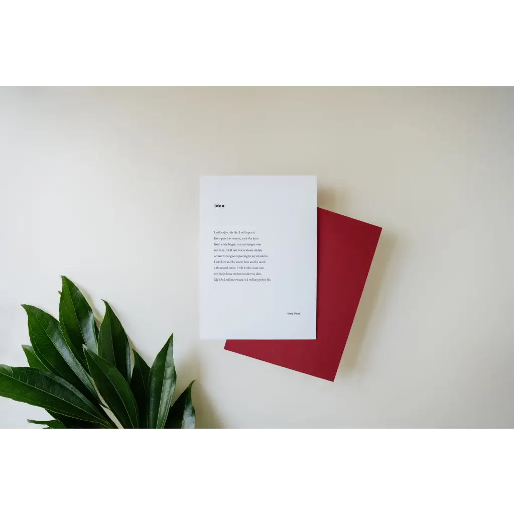 White paper with poetry next to a red notebook and green leaf, free shipping featuring art