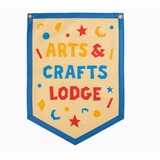 Shield-shaped banner with ARTS & CRAFTS LODGE by Kelle Hampton, featuring stars and moons