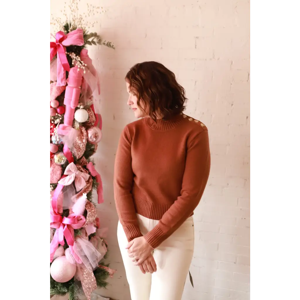 Stylish Ava Mock-Neck Sweater in brown with white pants on Christmas tree