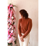 Stylish Ava Mock-Neck Sweater in brown with white pants on Christmas tree