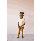 Child in white t-shirt and mustard pants showcasing Baby Cathay Spice Flexible Lightweight Leggings