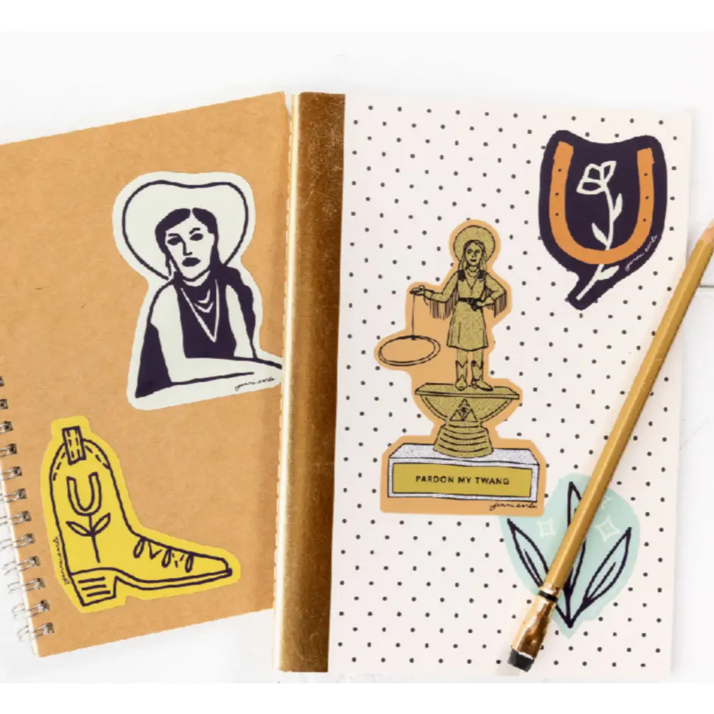 Two notebooks with western-themed stickers on a Bad Vibes Trophy Sticker from Polished Prints