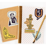 Two notebooks with western-themed stickers on a Bad Vibes Trophy Sticker from Polished Prints